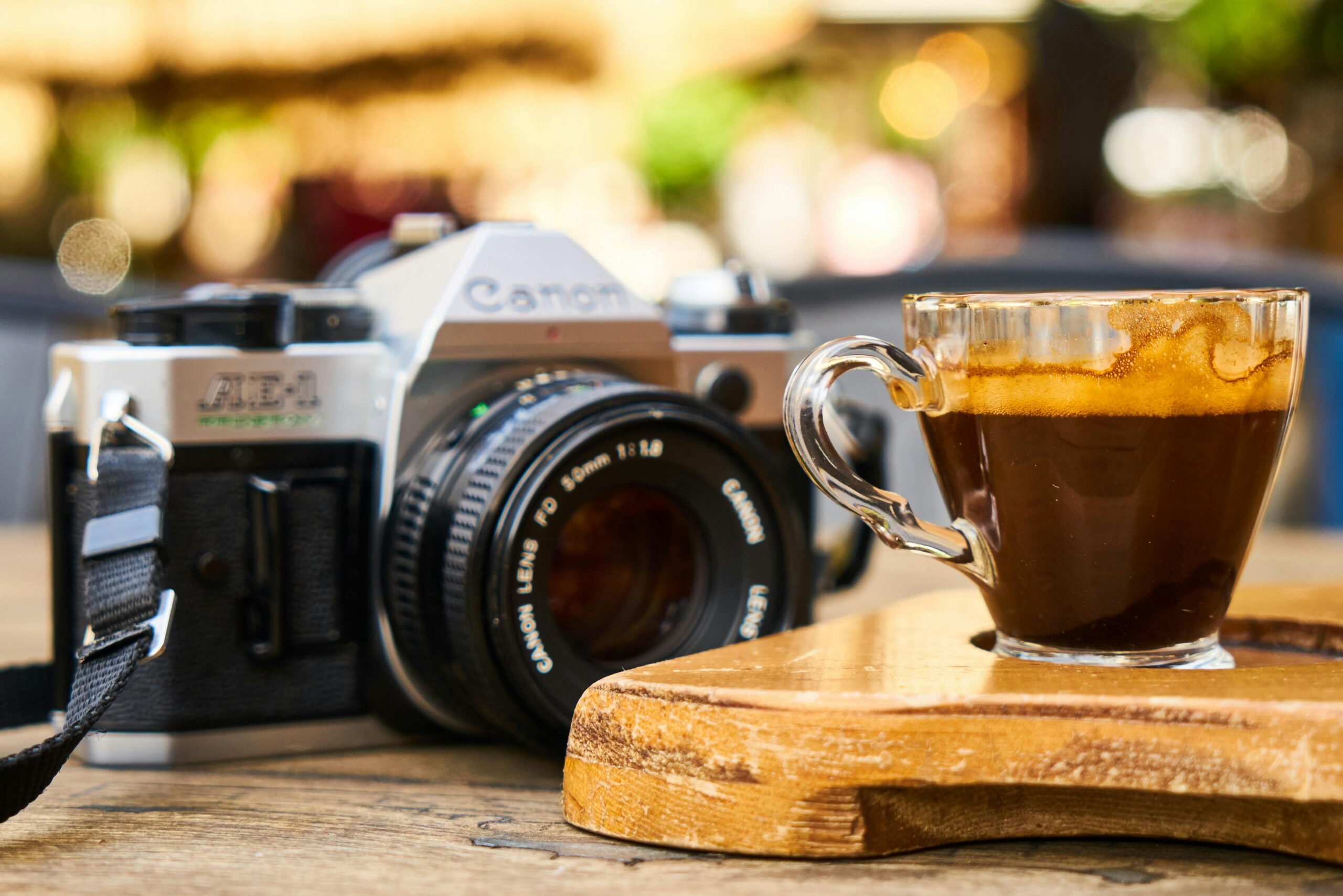 A classic scene featuring a freshly brewed espresso and vintage camera on a warm wooden table.