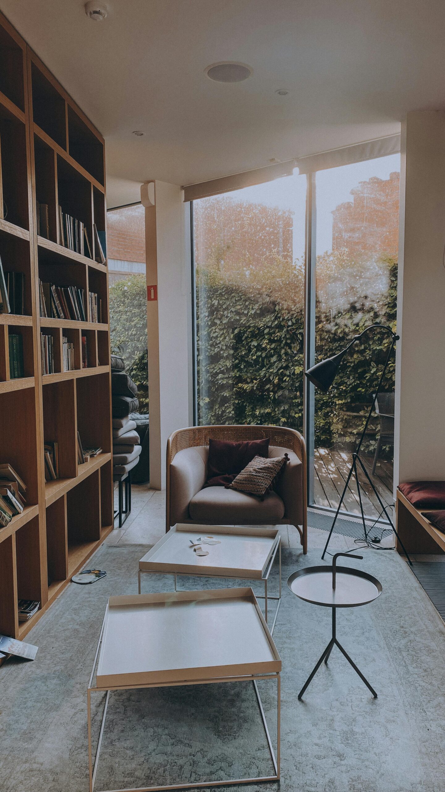 Inviting living room with bookshelves, a cozy chair, and stylish tables, perfect for relaxation.